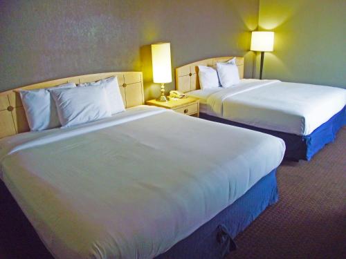 a hotel room with two beds and two lamps at Travelodge by Wyndham Memphis Airport/Graceland in Memphis