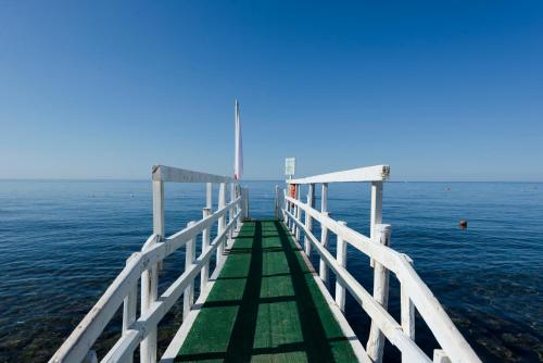 a pier in the water with a blue sky at Villino Emanuele in Santa Marinella