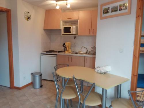 een kleine keuken met een tafel en stoelen bij STUDIO entre ciel et Lac in Thollon