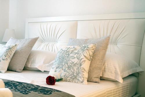 a white bed with pillows and a red rose on it at Green Diamond in Zagreb