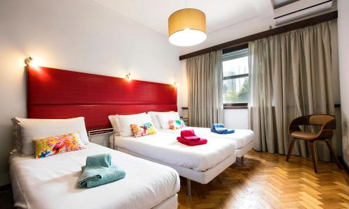 um quarto de hotel com duas camas e uma cabeceira vermelha em LV Premier Apartments Clerigos-RE2 em Porto