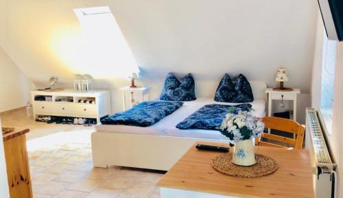 um quarto com uma cama com almofadas azuis e uma mesa em Landhaus Schlunt em Wustrow