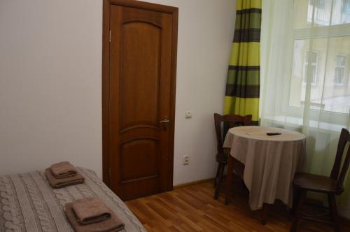 リヴィウにあるCozy Apartment in the Center of Lvivのベッド、テーブル、ドアが備わる部屋
