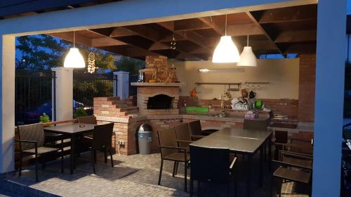 a kitchen and dining area with tables and a fireplace at Vila Pacific in Costinesti