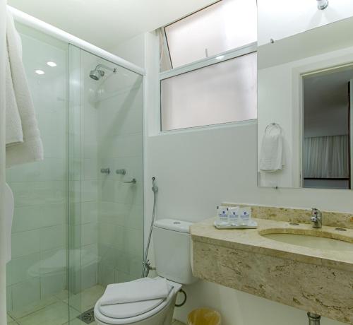 a bathroom with a toilet and a shower and a sink at Hotel Dan Inn Curitiba Centro in Curitiba