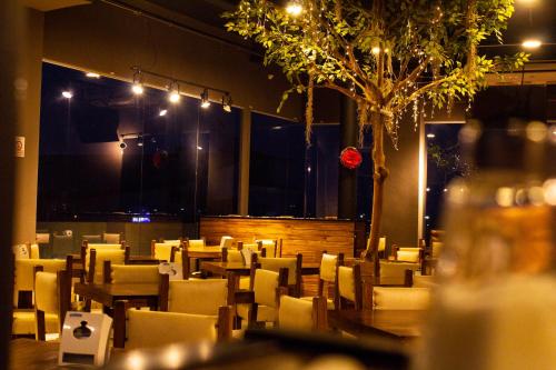 a restaurant with chairs and tables and a tree at Hotel Med Barranquilla Centro in Barranquilla