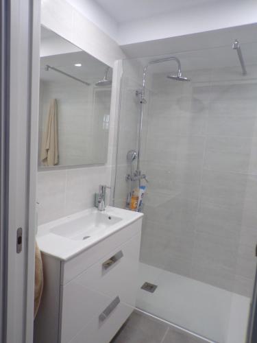 a white bathroom with a sink and a shower at La Colina in San Agustin