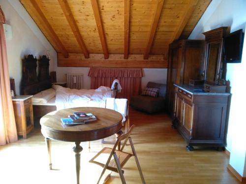 1 dormitorio y sala de estar con mesa y 1 cama. en SaMeCà, en Tione di Trento