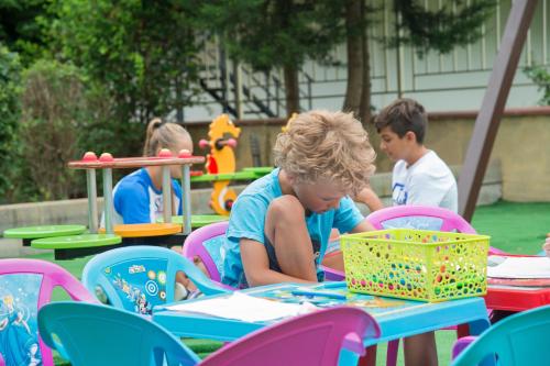 a group of children sitting at a table in a play set at Aparthotel Hotel Prestige City II in Primorsko