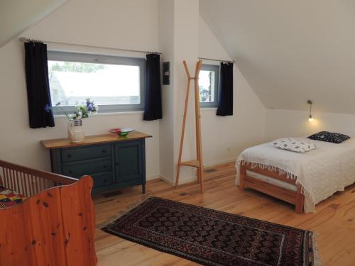 a bedroom with a bed and a dresser and a window at Stern am Kap 1 in Putgarten