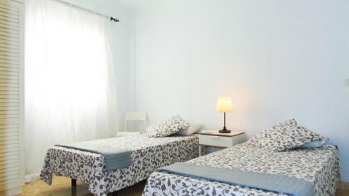 TeguesteにあるChocolate Rustic Apartment, in Teguesteのベッドルーム1室(ベッド2台、テーブルの上にランプ付)