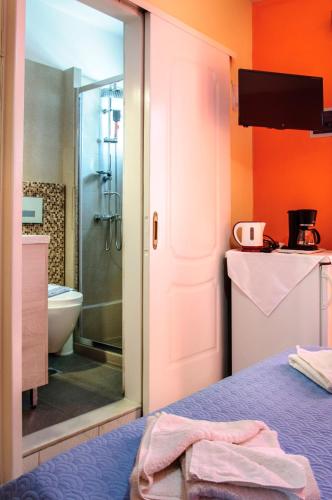 a bathroom with a bed and a shower and a toilet at Christina Rooms in Adamas