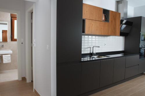 a kitchen with black cabinets and a sink at Luxury Poolside Villa in Slatine