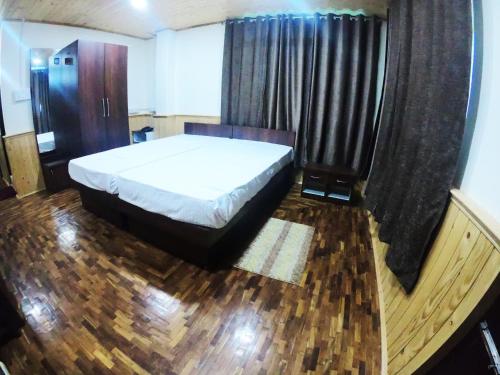a bedroom with a large bed and a window at Temi Sarika Homestay in Damthang