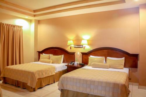 a hotel room with two beds in a room at Hotel Monteolivos in San Pedro Sula