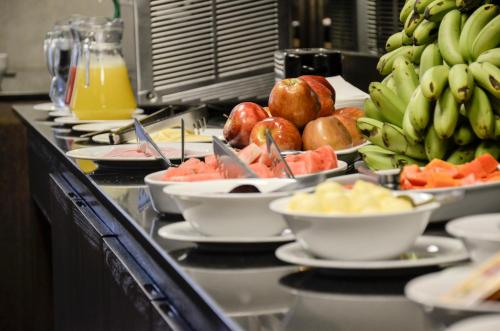 a buffet with plates of food and fruit on a counter at Gran Hotel Toloma in Cochabamba