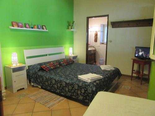 um quarto com uma cama e uma parede verde em Studio Apartment with garden and free parking em Giardini Naxos