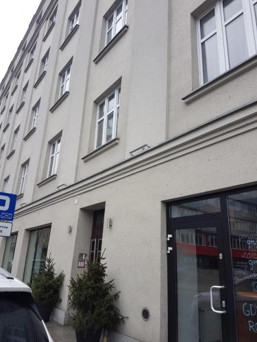 a large white building with windows on a street at KATO Apartamenty Moniuszki in Katowice
