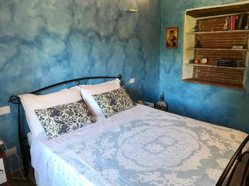 a bedroom with a bed with a blue wall at casamariu in Lucca