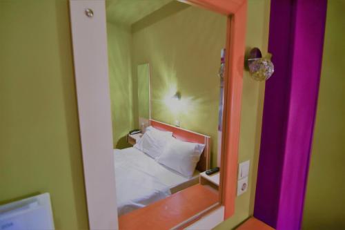 a mirror in a bedroom with a bed in it at Iridanos in Antikyra