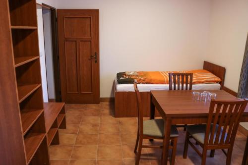 a room with a table and a bed and a bedroom at Ubytování Na prženských pasekách in Mikulŭvka