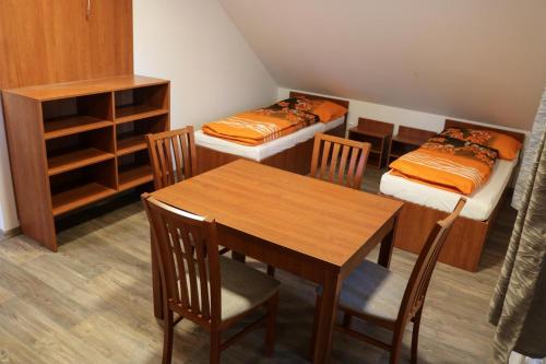 a room with a table and chairs and two beds at Ubytování Na prženských pasekách in Mikulŭvka