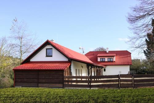 a house with a red roof and a fence at Ubytování Na prženských pasekách in Mikulŭvka