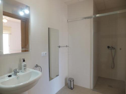 y baño blanco con lavabo y ducha. en Hostal El Paraiso Playa Alicante, en Alicante
