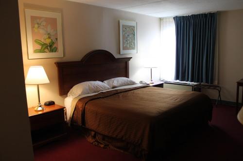 a hotel room with a bed and a window at Rodeway Inn in Little Falls