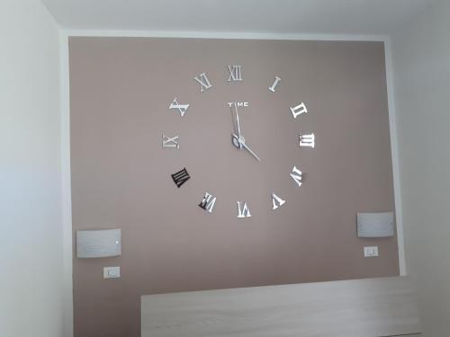 a clock on a wall in a room at Le camere di Sabrina con bagno in camera in Sarzana