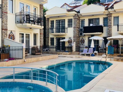 a swimming pool in the courtyard of a building with two buildings at Dove Apart Hotel in Fethiye