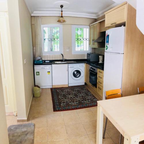 a kitchen with a white refrigerator and a dishwasher at Dove Apart Hotel in Fethiye