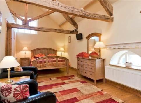 a room with a bedroom with a bed and chairs at Henllys Estate B and B in Llandovery