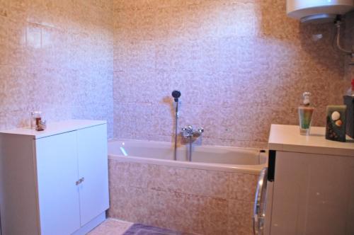a bathroom with a tub and a white cabinet at Spacious Apartment in quiet surrounding in Ičići