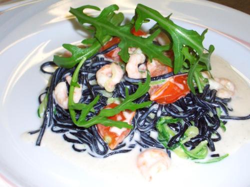 a plate of food with noodles and shrimp and green peppers at Gasthof Obermair in Chienes