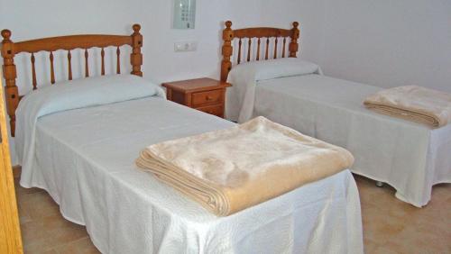 Habitación con 2 camas y mantas blancas. en Mariarosa Sol, en Sanxenxo
