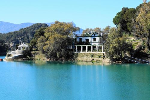 a house on a island in the middle of a lake at Casabobastro in Ardales