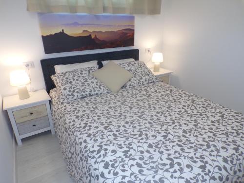 een bed in een slaapkamer met 2 nachtkastjes en 2 lampen bij La Colina in San Agustin