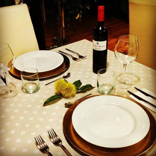 a table with two plates and a bottle of wine at A Cantaruxa Maruxa Turismo Rural in Mondariz