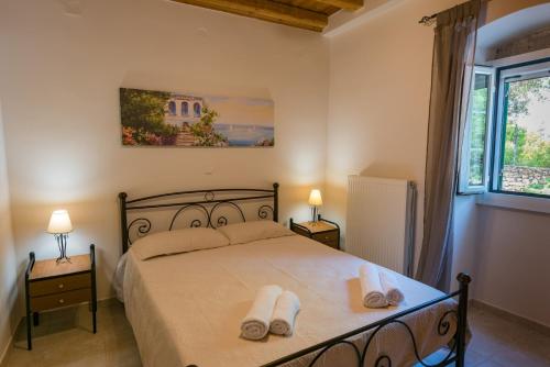 ein Schlafzimmer mit einem Bett mit zwei Handtüchern darauf in der Unterkunft Villa Demetra 1768 in Fiskardo