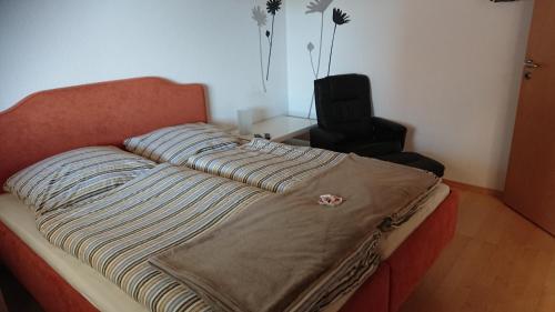 ein Bett mit einer Decke auf dem Zimmer in der Unterkunft Gasthaus zum Löwen in Seckach