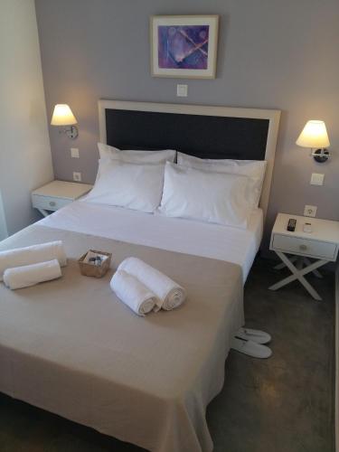 a bedroom with a large white bed with towels on it at Sea Colours Parga in Parga