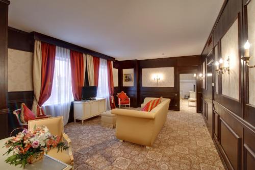 a living room with a couch and chairs and a television at Optima Collection Troitska in Dnipro