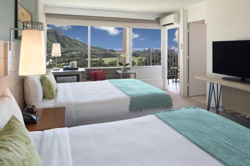 Кровать или кровати в номере Queen Kapiolani Hotel
