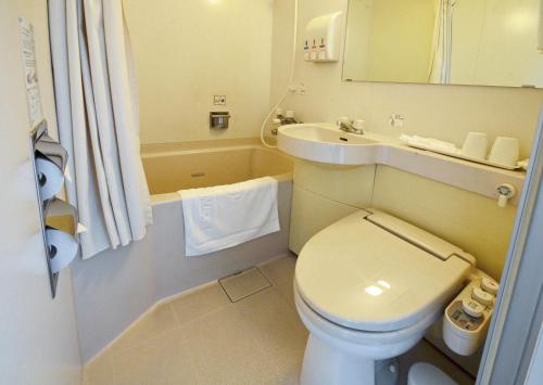 a small bathroom with a toilet and a sink at Omura Central Hotel in Omura