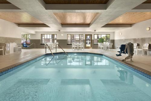 a large swimming pool with a person walking in front of it at Country Inn & Suites by Radisson, St Cloud West, MN in Saint Cloud