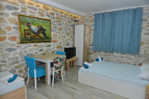 a room with a bed and a table and a bed and a couch at Rooms Ela Ela in Prekodolce