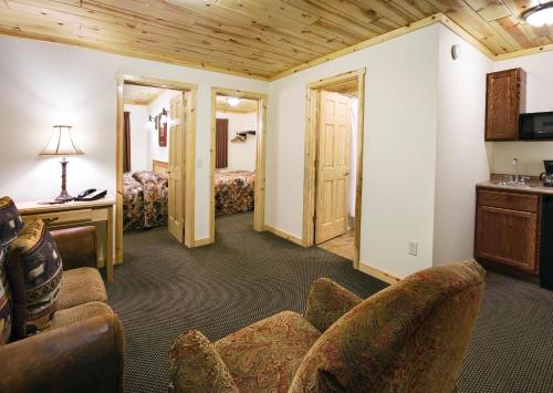 a living room with a couch and a bedroom at Rock Crest Lodge & Cabins in Custer