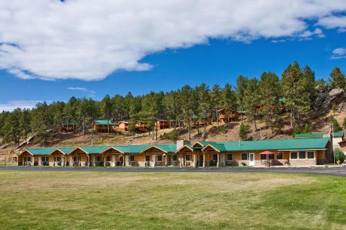 a large building with a green roof on a mountain at Rock Crest Lodge & Cabins in Custer