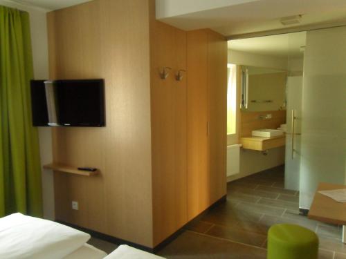 a hotel room with a television on a wall at Gasthof-Pension Schütz in Wesenufer